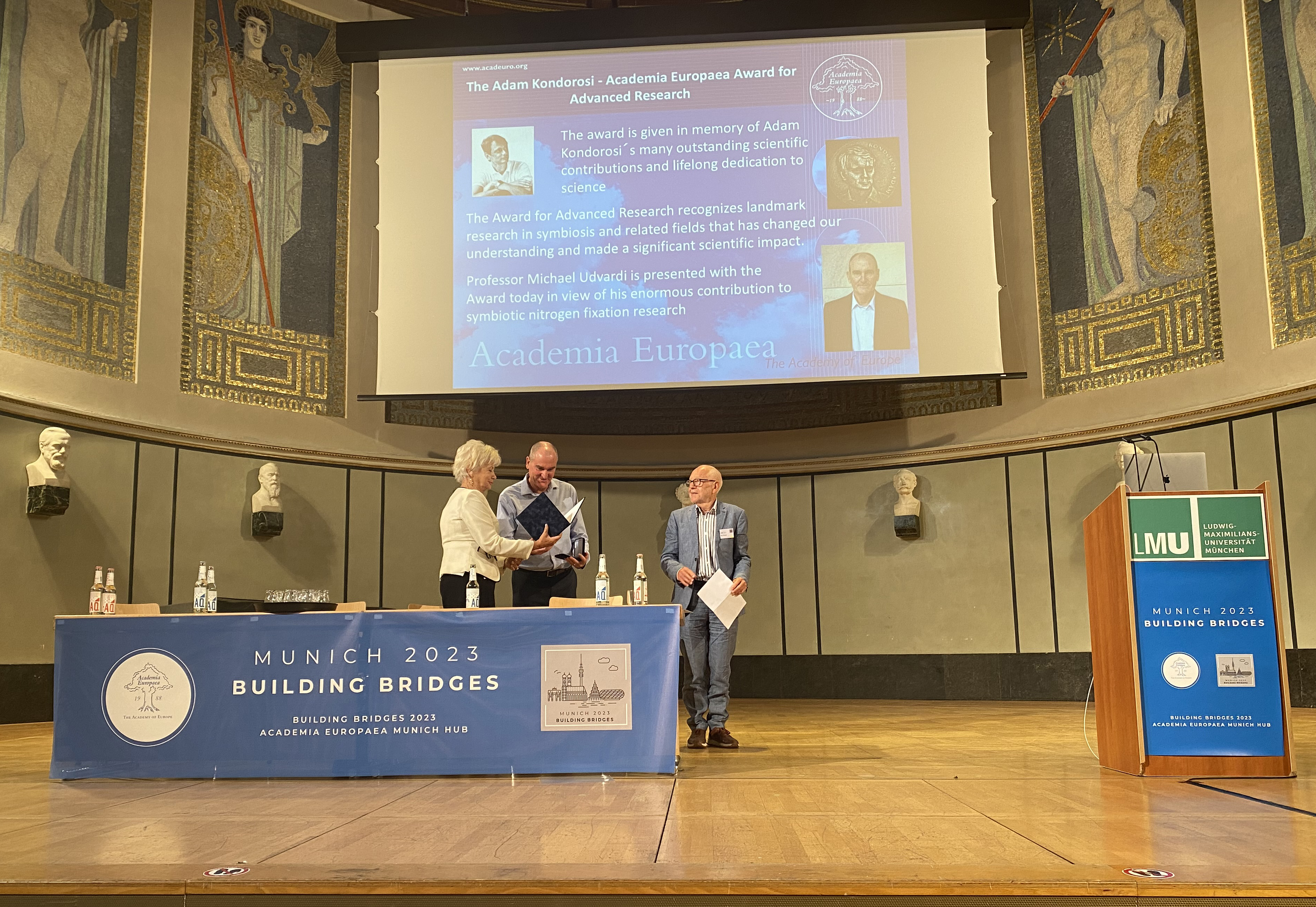 Professor Eva Kondorosi presents the award certificate to Prof. Udvardi